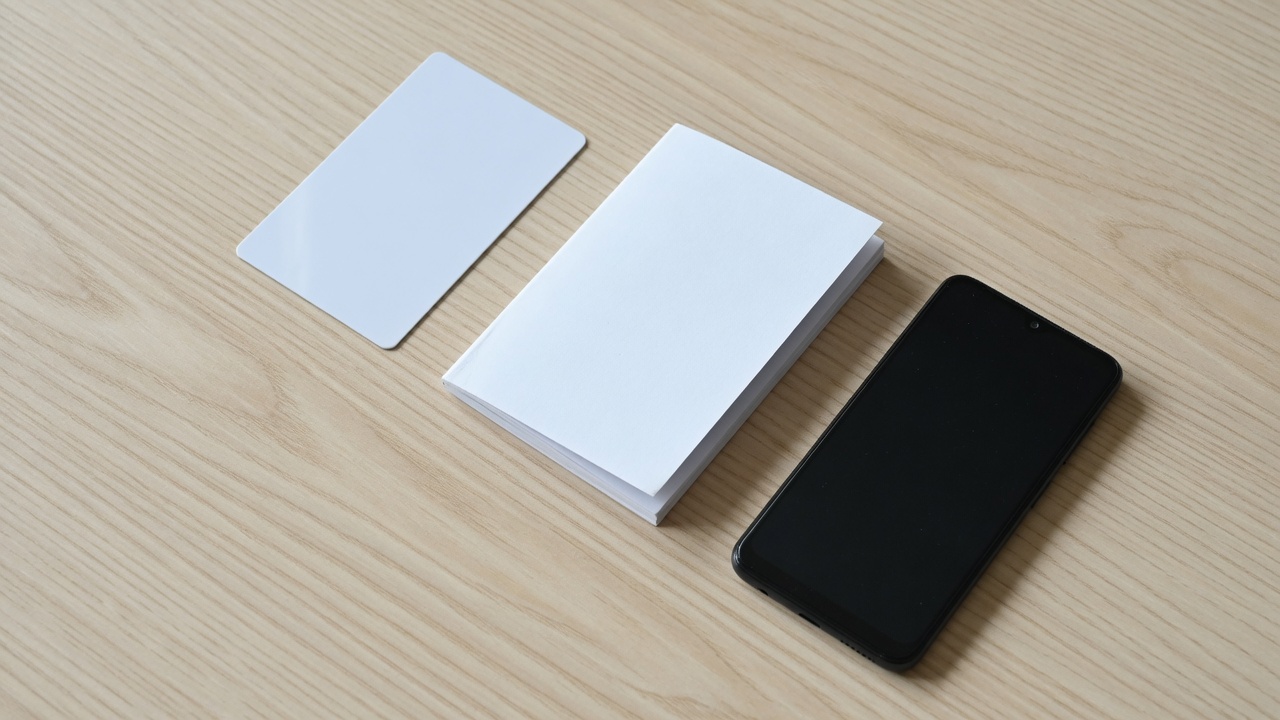 机の上に並べられた無地のカードと冊子、スマートフォン